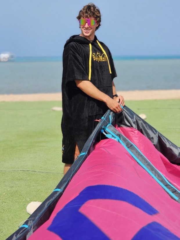 Surf Poncho BejkRoll WAVE MASTER - black - boy inflating a kite - front
